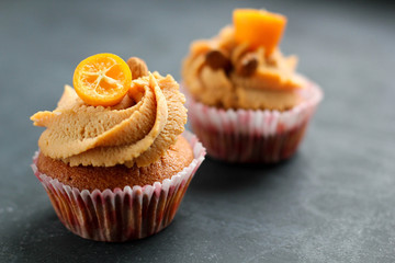 Cream caramel cupcake on black board decorated by almonds
