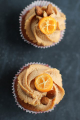 Cream caramel cupcake on black board decorated by almonds