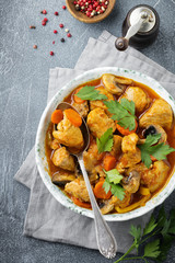 Goulash traditional Hungarian dish. Stew with pepper and tomato sauce in  vintage ceramic plate on  dark sine stone or concrete background. Selective focus. Top view.