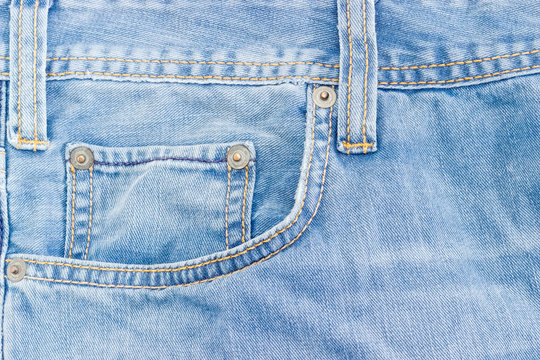 Fragment of the top of the old light blue jeans