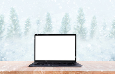 Computer,laptop with blank screen on snowfall in winter season