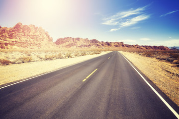 Fototapeta premium Vintage toned desert road, travel concept picture, Valley of Fire State Park, Nevada, USA. 