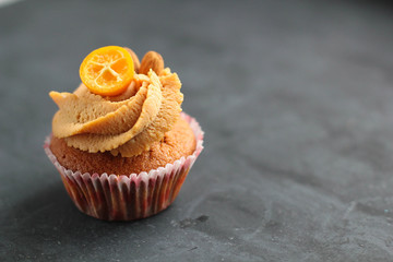 Cream caramel cupcake on black board decorated by almonds
