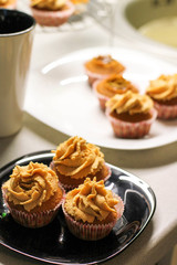 Cream caramel cupcake on black board decorated by almonds