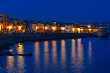 Fototapeta na wymiar Coast of Ortigia island panoramic view at night, Syracuse, Sicily, Italy