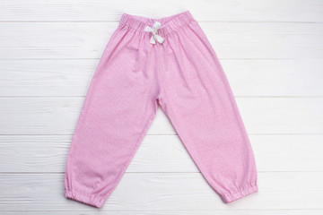 Pink pants with white drawstring. Simple design of garment. Snug nightwear for little girls.