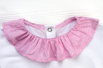 Ruffle collar of sleepwear jacket. Pink and white cotton textile. Cute pajama top for girls.