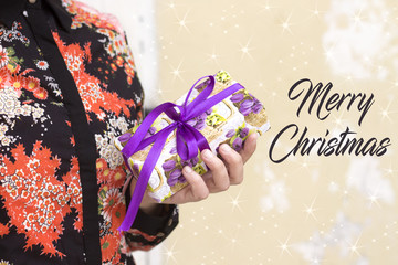 woman holding a gift box with purple ribbon,merry christmas