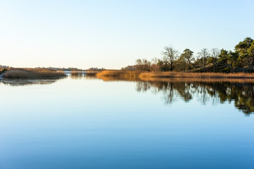 Obraz premium Windless coastal morning with mirror like sea and the beginning of a lovely day. Location Nattraby archipelago near Karlskrona, Sweden.