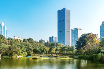 Fototapeta na wymiar The skyscraper is at the lakeside of the park, chongqing, China