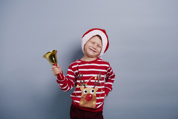 Cheerful boy with handbell at studio shot .