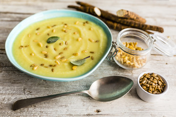 Delicious scorzonera cream soup with pine nuts and seeds.
