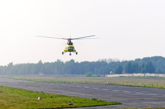 A transport helicopter take off from runway in a small airport.