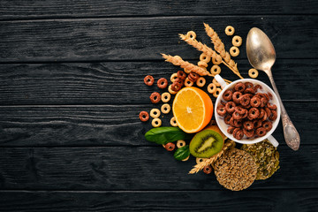 Fitness breakfast, muesli, milk, fruits, nuts and seeds, on a wooden surface. Top view. Free space for text.