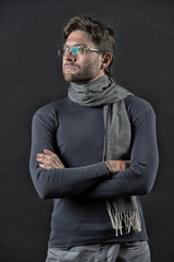 Man in scarf and sweater with folded hands