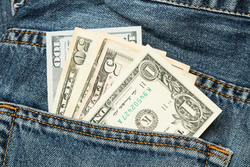 Dólares dentro de un bolsillo de un pantalón de jean. Vista superior y de cerca