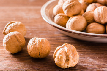 Walnuts in a plate and lie on a ceramic table