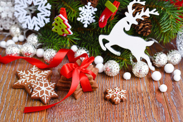 Christmas cookies with festive decorations and spruce branches on a wooden table