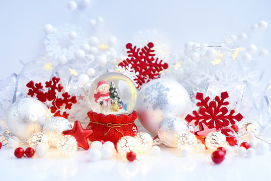 A snow globe with snowman with Christmas decorations and Christmas lights. Festive Christmas background.