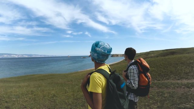 Hiking Couple Exploring Olkhon island in beautiful blue lake Baikal. Travel nature footage man woman enjoying adventurous vacation beauty backpacker tourist. Olkhon Island, Baikal, Russia, Siberia