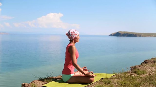 Slender fit woman doing yoga on exercise mat near blue lake. Olkhon Island, Baikal, Russia, Siberia. Healthy Active Lifestyle concept