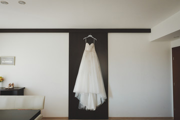 Fototapeta na wymiar White wedding dress on black door and white wall
