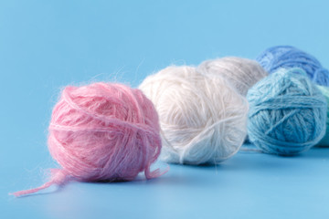 Fototapeta na wymiar Needlework hobby concept. Wool clews on blue background