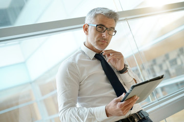 Fototapeta premium Businessman in office connected with digital tablet