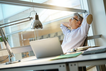 Businessman in office relaxing in desk chair