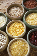 Bowls of various cereals in small containers on a wooden background, Cereal Mix, Beans, sesame, rice, pearl barley, wheat, Closeup, Selective focus