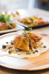 Chicken fillet steak with mushroom cream sauce serving on a wooden plate.