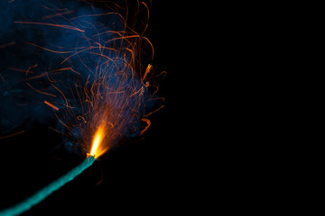 Burning fuse with sparks and blue smoke isolated on black background