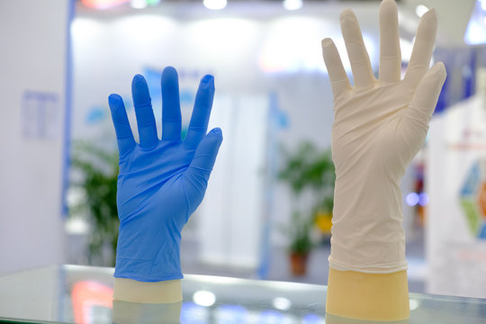 Blue and white latex gloves on hand