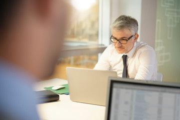 Fototapeta premium Mature businessman in office working on laptop