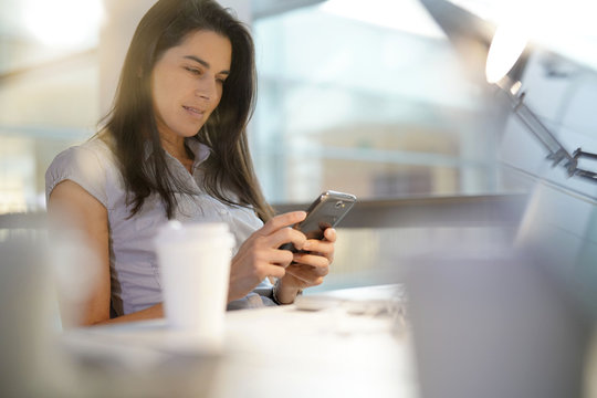 Businesswoman in office using smartphone