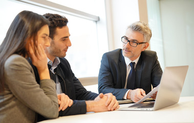 Young couple meeting financial advisor for home investment