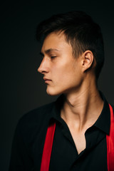 Portrait young guy on a dark studio