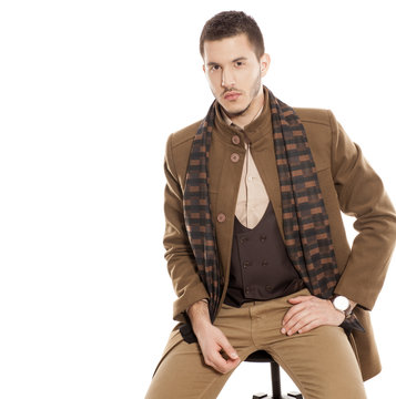 young handsome man in winter clothes with a scarf on white background
