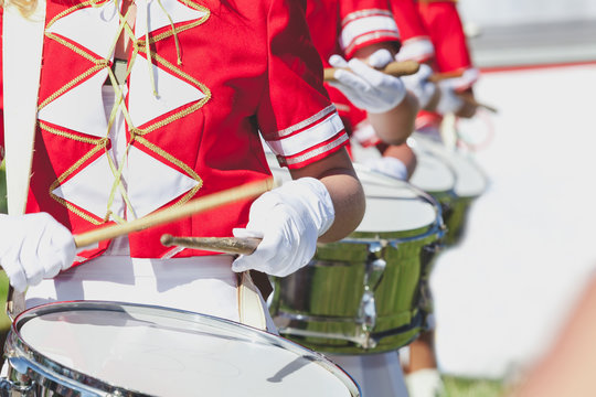 girl in red coat playing marching drum