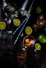 Obraz na płótnie Canvas Cuba Libre, long island or iced tea cocktail with strong alcohol, cola, lime and ice, two glass, dark background copy space top view
