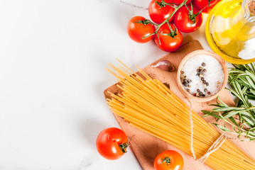 Italian food cooking, ingredients for preparation pasta spaghetti - tomato, garlic, olive oil, spices, white marble background, copy space top view