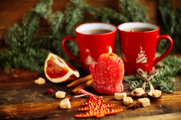 Christmas composition. Christmas cake pan de pasqua, red mug of tea and Christmas New Year decoration - fir brunches, fir and pine cones, New Year balls, red napkin on black background