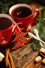 Christmas composition. Christmas cake pan de pasqua, red mug of tea and Christmas New Year decoration - fir brunches, fir and pine cones, New Year balls, red napkin on black background