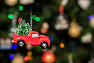 Red pickup car with Christmas tree hanging on Christmas tree
