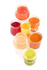 Glasses with fresh organic vegetable and fruit juices isolated on white.