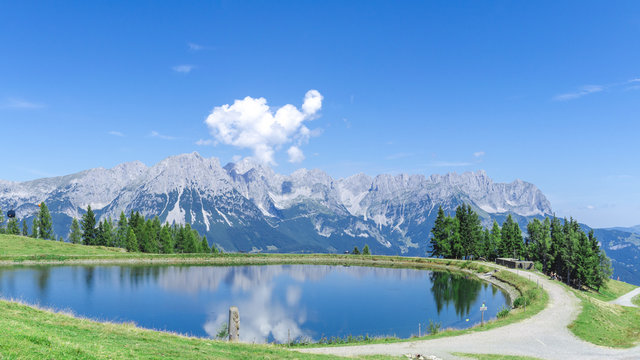 Panorama vom Wilden Kaiser in Tirol bei Sonnenschein und blauem Himmel mit Blick von den Bergen (Hartkaiser) in Ellmau