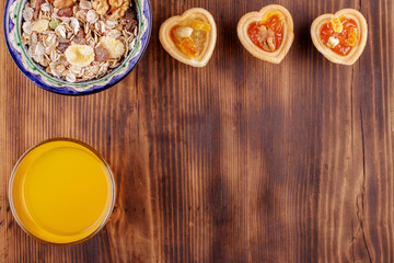 Healthy breakfast. Ceramic bowl with oat flakes, dried fruits, nuts on wood background, copy space