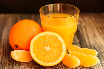 Oranges and orange juice on a wooden background