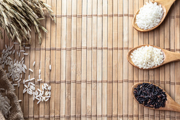 Thai Jasmine rice ,Organic Riceberry , Japanese rice In the wooden spoon and ear of rice on the table .