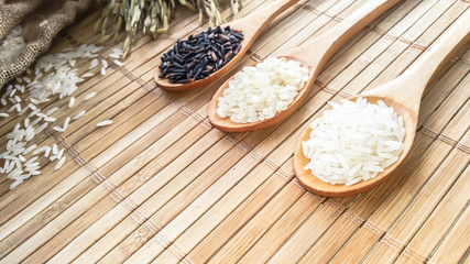 Thai Jasmine rice ,Organic Riceberry , Japanese rice In the wooden spoon and ear of rice on the table .